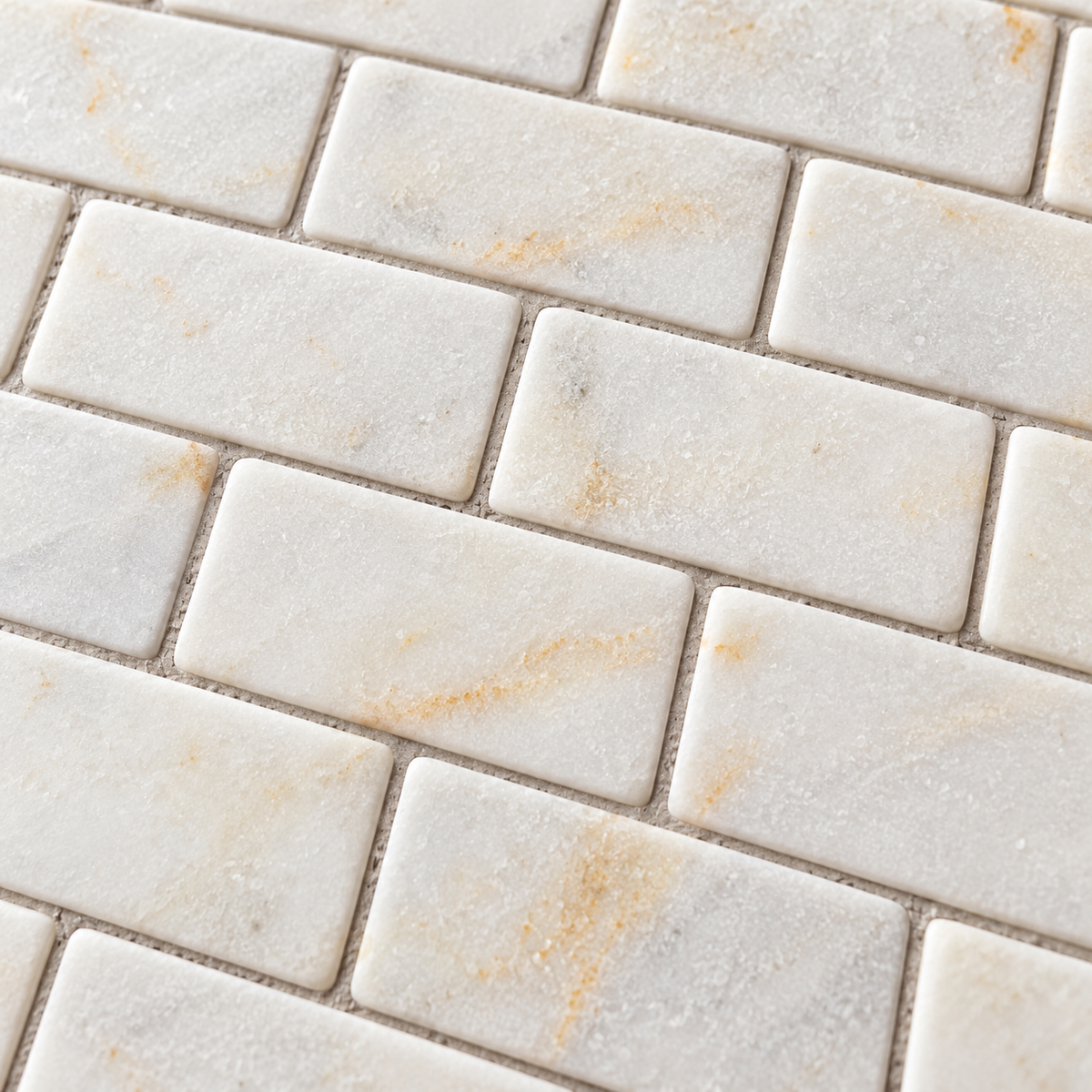 Calacatta Sugar Tumbled Marble Brick Mosaic Tiles 50x100: close-up of the natural stone texture, pattern and grout joints