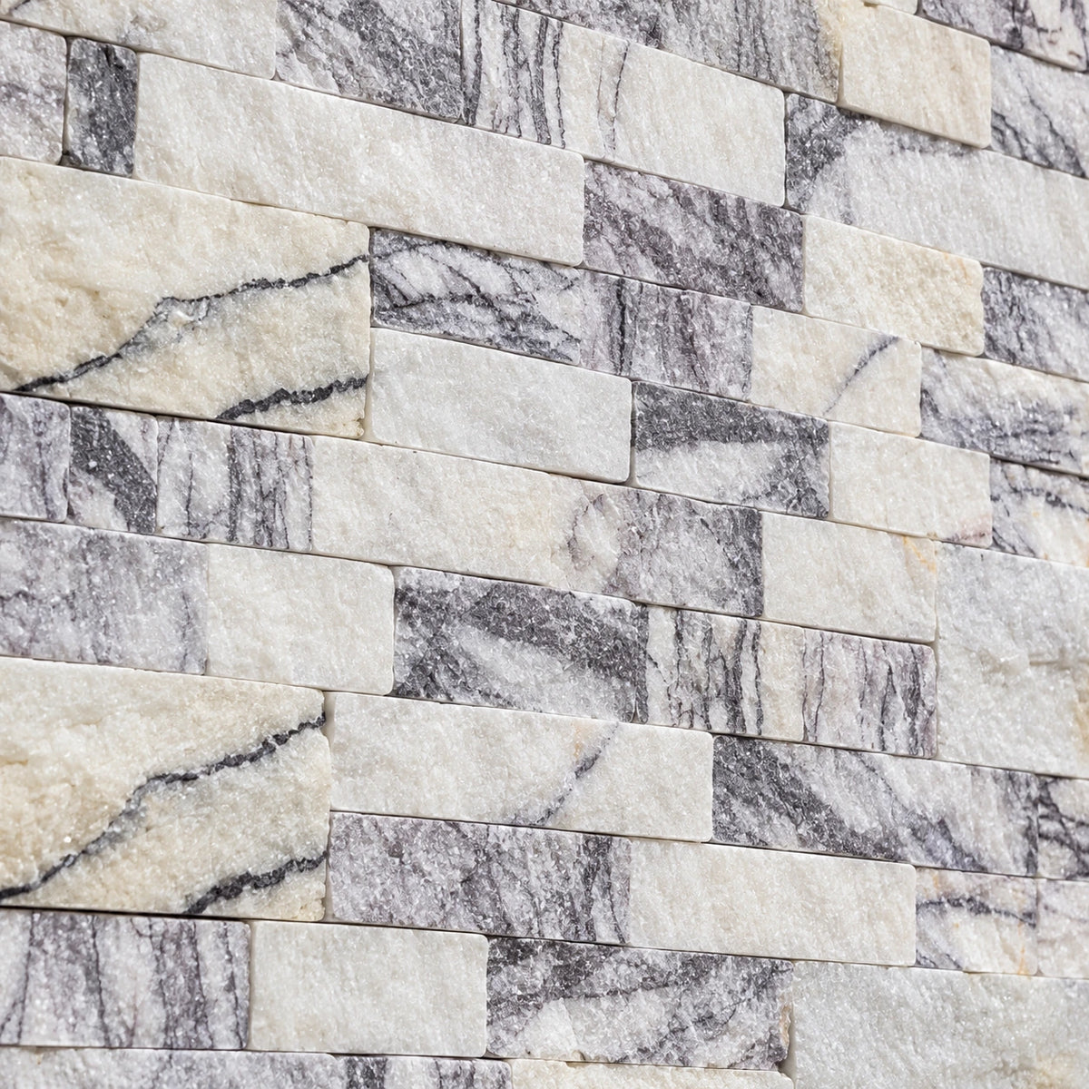 Close-up of Calacatta Viola split face marble with ivory tones, grey-lilac veining and a textured surface.