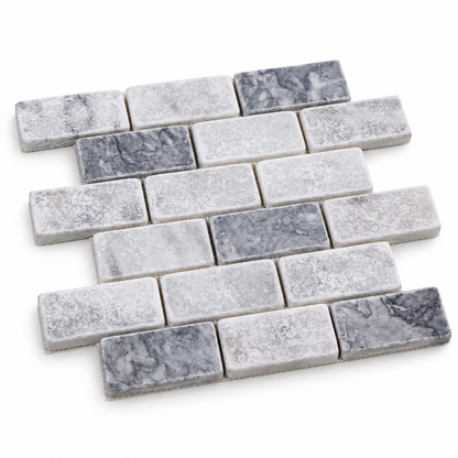 Carrara White - Platinum Grey Tumbled Marble Brick Mosaic Tiles — angled sheet showing natural marble edges and mesh backing