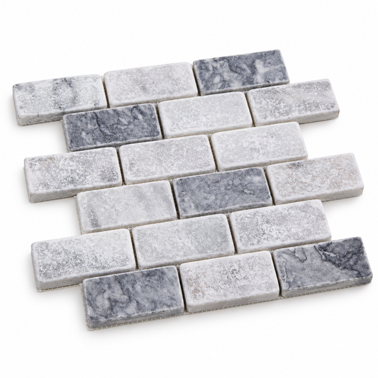 Carrara White - Platinum Grey Tumbled Marble Brick Mosaic Tiles — angled sheet showing natural marble edges and mesh backing
