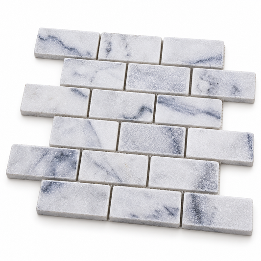 Carrara White Tumbled Marble Brick Mosaic Tile 50x100 — angled sheet showing 10 mm natural marble edges and mesh backing