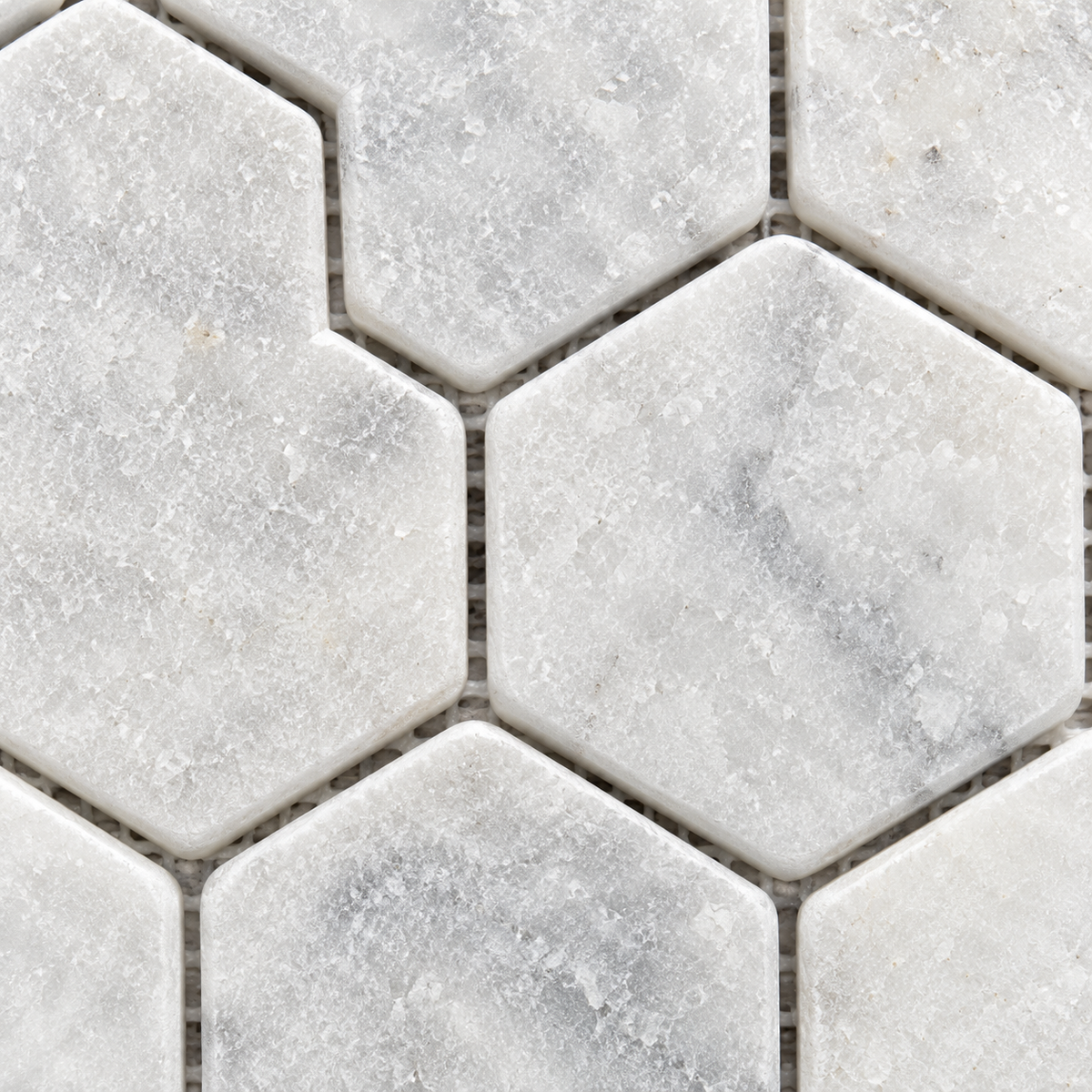 Carrara White Tumbled Marble Hexagon Mosaic Tile 48x48 — macro close-up of natural marble texture, finish and mosaic chip detail