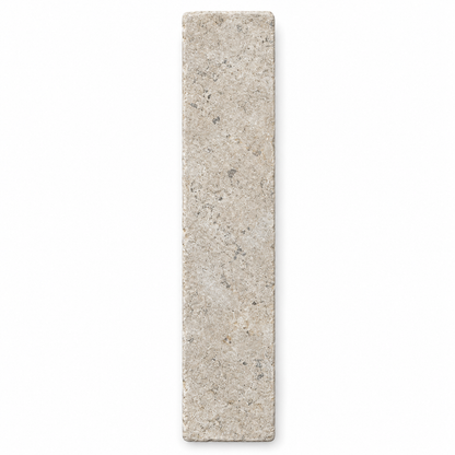 Dijon tumbled limestone 50 x 200 mm herringbone tile viewed from above, showing natural grey-beige markings and softened edges.