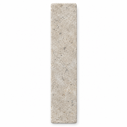 Dijon tumbled limestone 50 x 200 mm herringbone tile viewed from above, showing natural grey-beige markings and softened edges.