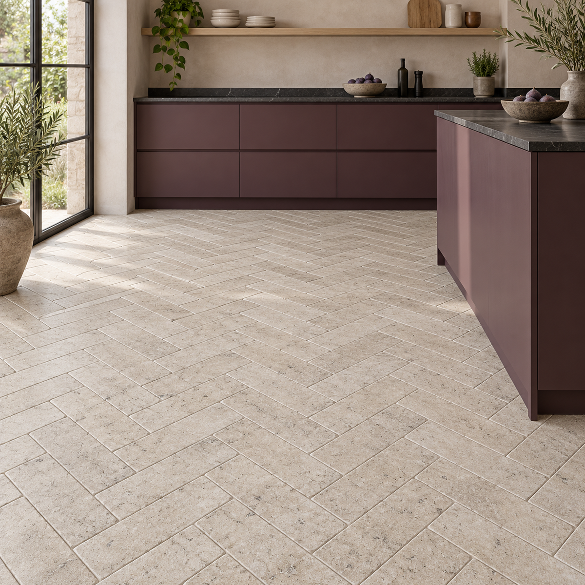 Dijon tumbled limestone 50 x 200 mm tiles laid in herringbone on a kitchen floor with plum cabinets.