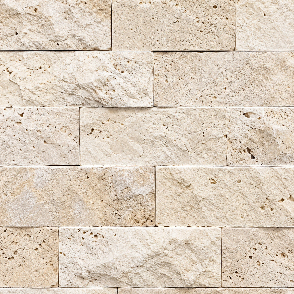 Close-up of light travertine split face stone with cream tones, natural pores and a textured surface.