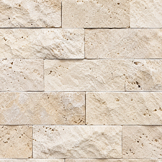 Close-up of light travertine split face stone with cream tones, natural pores and a textured surface.