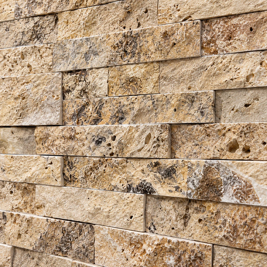 Close-up of scabos travertine split face stone showing natural colour variation, pores and a textured surface.