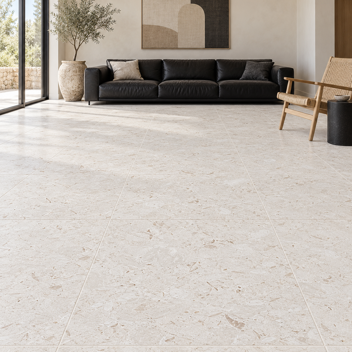 Shellstone brushed limestone 610 x 610 mm square floor tiles in a living room with a black leather sofa.