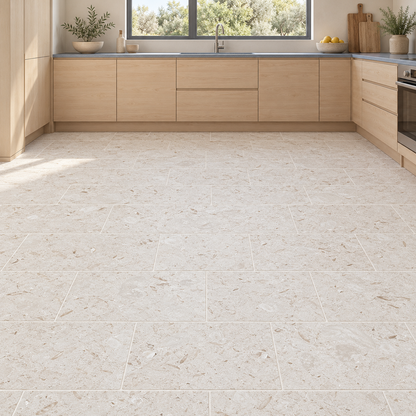 Shellstone brushed limestone 610 x 305 mm floor tiles laid in brick bond in a kitchen with pale maple cabinets.