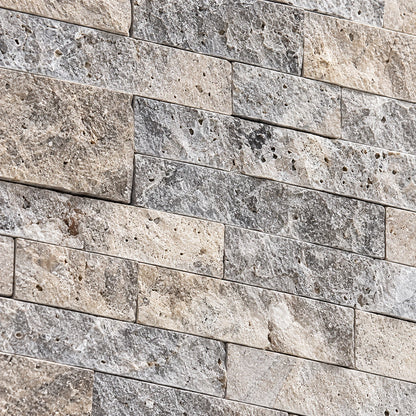Close-up of silver travertine split face stone showing natural colour variation, pores and a textured surface.